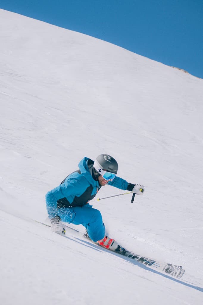 Alpine skier carving a turn on a sunny slope